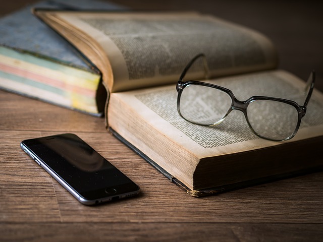 brýle na knize u mobilu